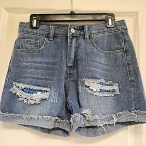 Distressed jean shorts with blue flower patches.